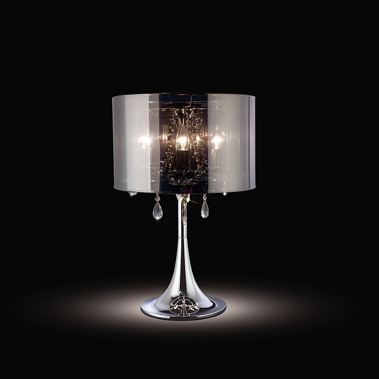 The Trace 3 Light Crystal Table Lamp features a chrome base and shade, hanging crystal accents, and three bulbs for striking accent lighting against a black backdrop.