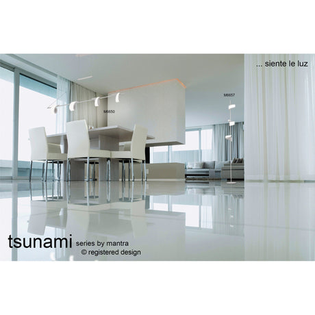 Modern, minimal dining and living area with large windows, white walls, glossy floors, sleek table and chairs, ambient lighting, and Tsunami LED Floor Lamp 36W 3000K - Sand White. Text: "tsunami series by mantra" and "...siente le luz".