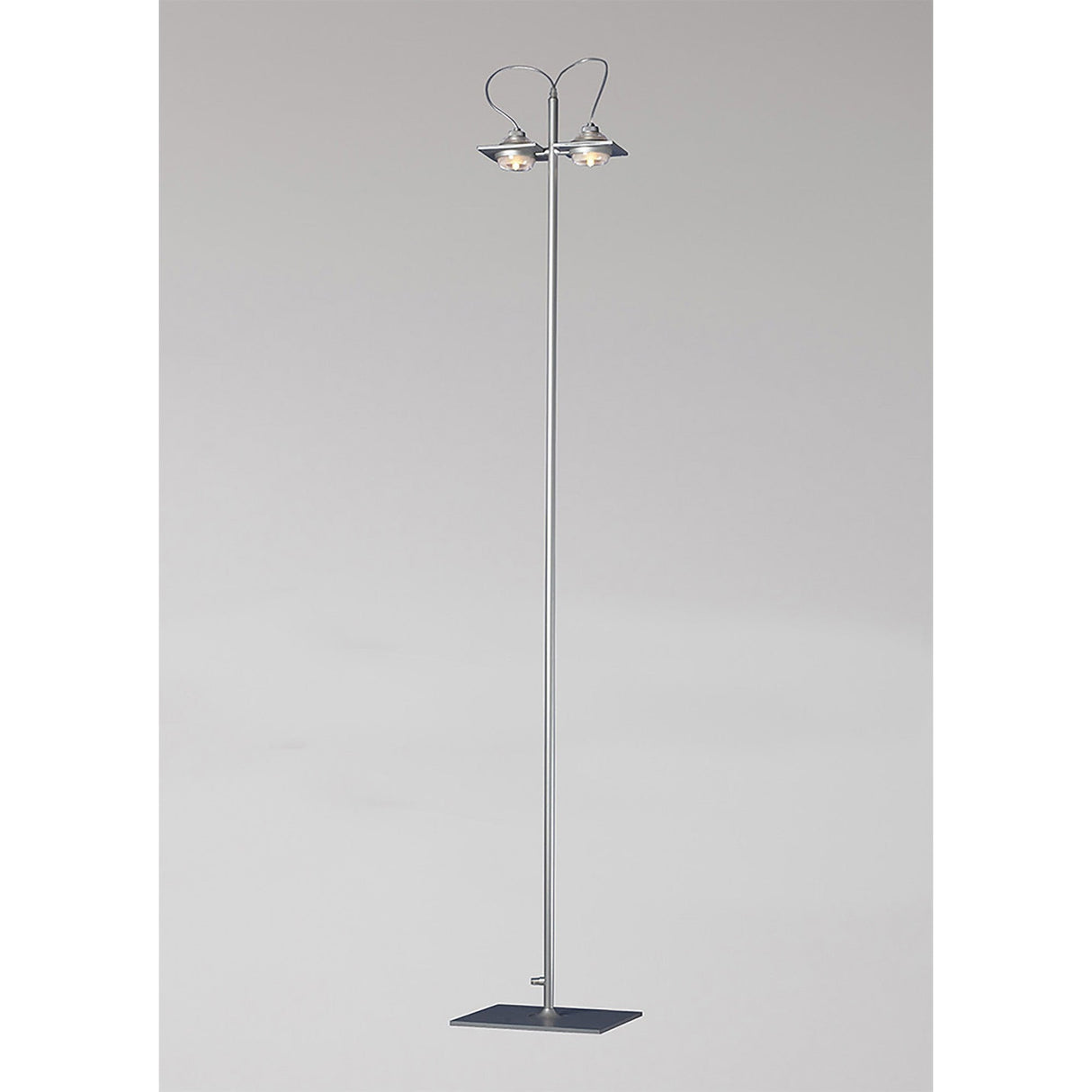 The Ull 2 Light Floor Lamp - Silver features a modern, minimalist design with a slim silver pole, square base, and two upward-facing cone lamps for ambient lighting. It is shown against a plain light gray background.