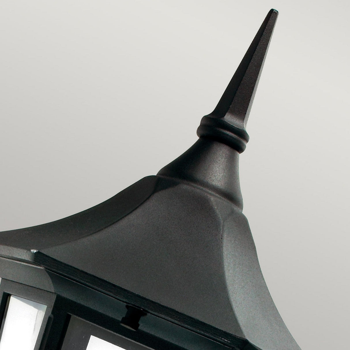 Close-up of the Valencia Outdoor 1 Light Up Lantern in black, crafted from die-cast aluminum, with a pointed top against a light grey background. The lantern features clear panels, highlighting its elegant traditional style and weather-resistant finish.