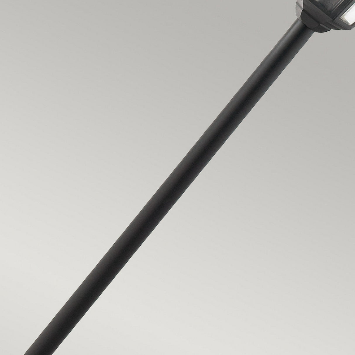 Close-up of a long, black handle that mirrors the sleek design of a Valencia 1 Light Pillar - Black, set against a neutral gray background. The end of the tool is not visible, highlighting the smooth, matte finish reminiscent of refined outdoor fixtures.