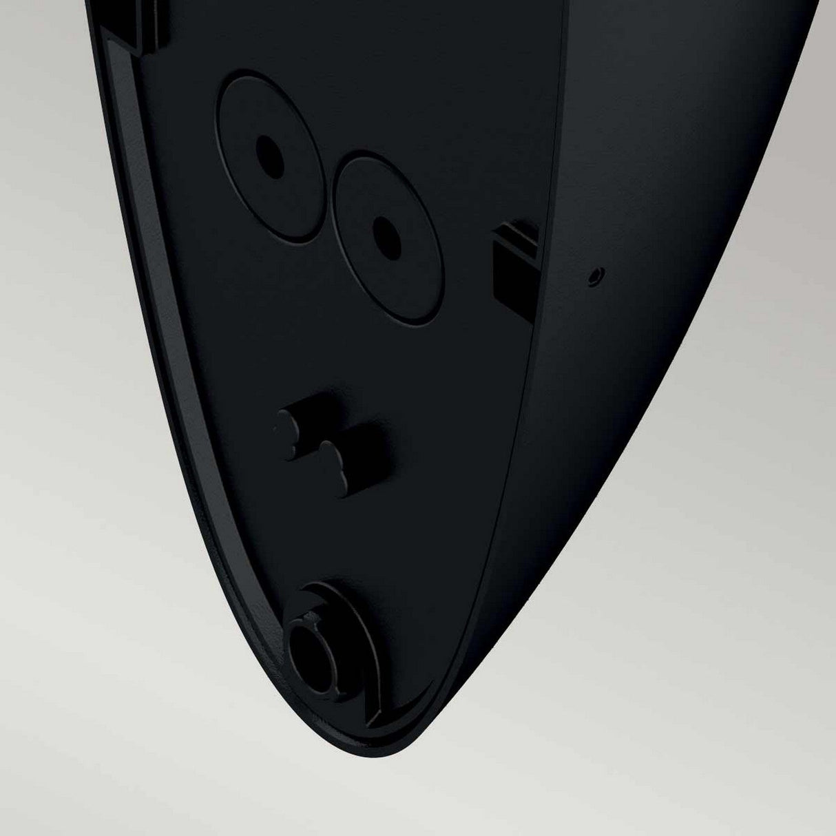 Close-up view of a black, triangular plastic component with multiple circular and rectangular cutouts, likely part of the energy-efficient Vendela Outdoor LED Wall Light - Black or its accessory, set against a plain light gray background.
