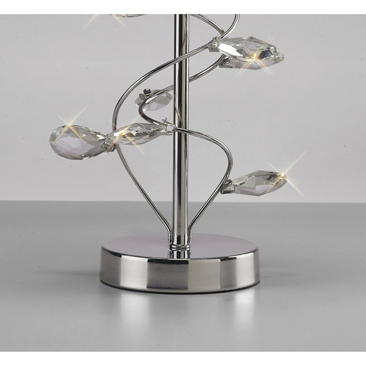 The Willow 1 Light Crystal Table Lamp features a sleek chrome finish and elegant crystal accents spiraling around the stem, topped with a white shade for a sparkling, modern look.