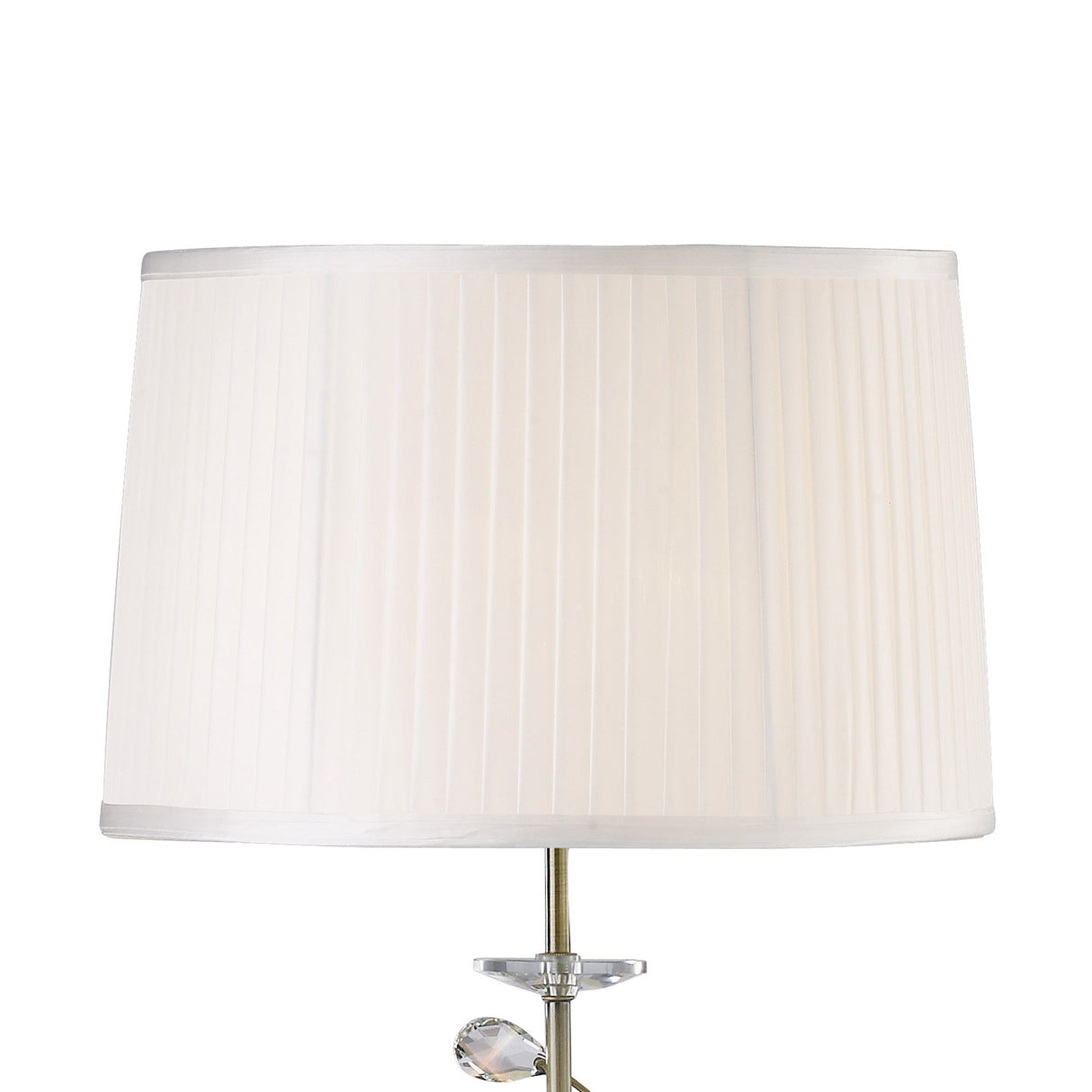 A close-up of the Willow 1 Light Crystal Floor Lamp in brass, featuring a white pleated shade and an elegant crystal base, with part of the stylish silver-finished bottom visible.