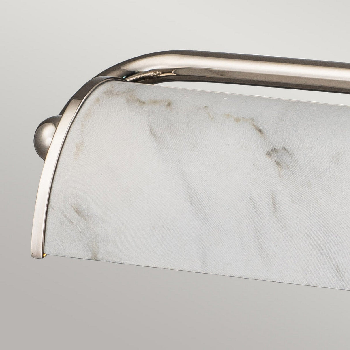 The Winchfield 4 Light Large Picture Light in polished nickel showcases a sleek, curved design complemented by a white marble effect shade. This close-up emphasizes the smooth texture and subtle veining of the alabaster surface against a neutral gray background.