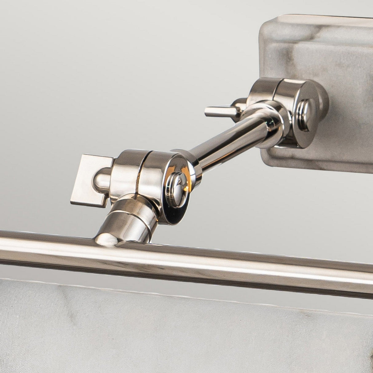 Close-up of the Winchfield 4 Light Large Picture Light, featuring a polished nickel finish with a white marble effect fixture. The sleek design emphasizes its contemporary style and functionality.