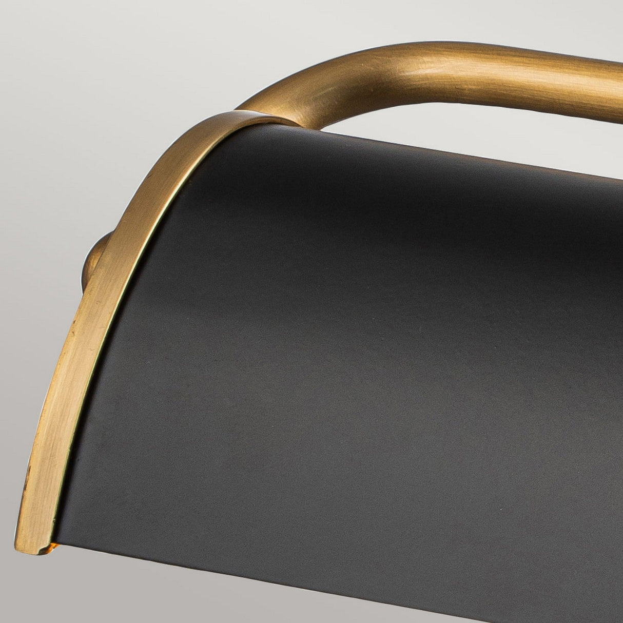 Close-up of the Winchfield 2 Light Medium Picture Light, showcasing its sleek, curved design in matte black with aged brass accents. This piece boasts a modern, minimalistic aesthetic that elegantly blends simplicity and sophistication.
