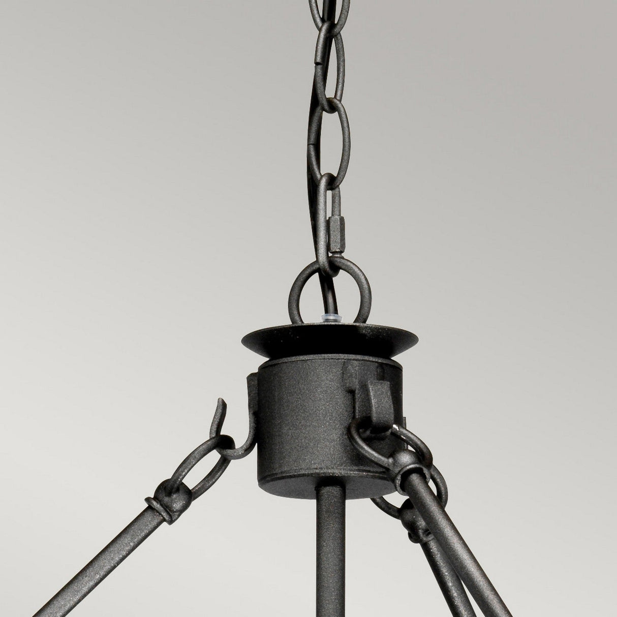 Close-up of the chain and mounting bracket of the Windsor 12 Light Chandelier - Graphite, featuring a black metal with a graphite finish against a plain gray background. The image highlights a robust, industrial-style connection with links and a central hanging point, ideal for statement lighting.