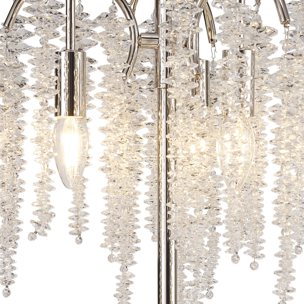 Close-up of the Wisteria 3 Light Table Lamp in nickel, featuring clusters of clear crystals and exposed bulbs. Its dimmable lighting enhances the sparkling effect as crystals reflect a warm glow.