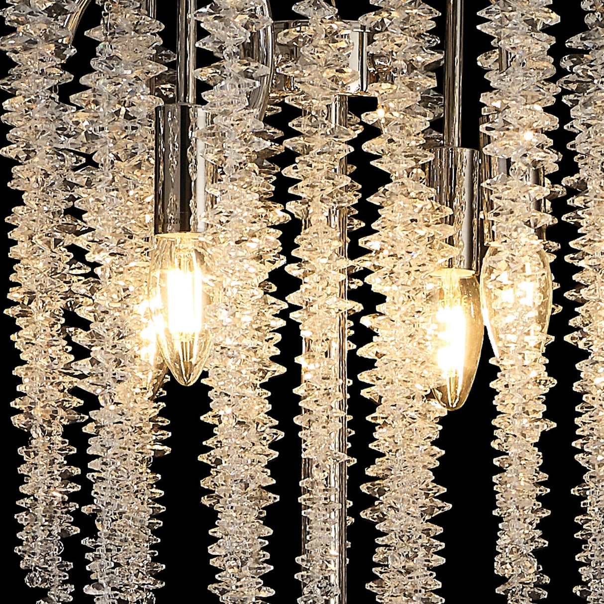 Close-up of the Wisteria 4 Light Crystal Floor Lamp in polished nickel, featuring four glowing bulbs and cascading faceted crystals that sparkle brilliantly against a dark background.