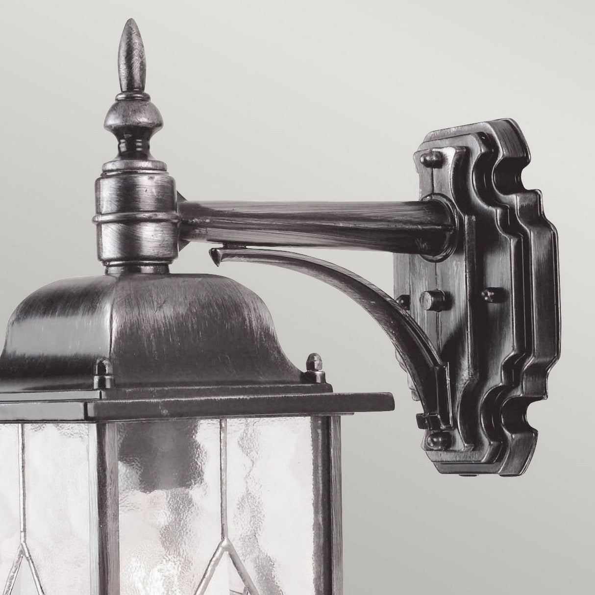 The Wexford 1 Light Outdoor Down Wall Light in Black/Silver showcases an ornate, vintage design with metal detailing, featuring a decorative finial and glass panels. This weather-resistant lantern extends horizontally from a wall mount against a light gray background.