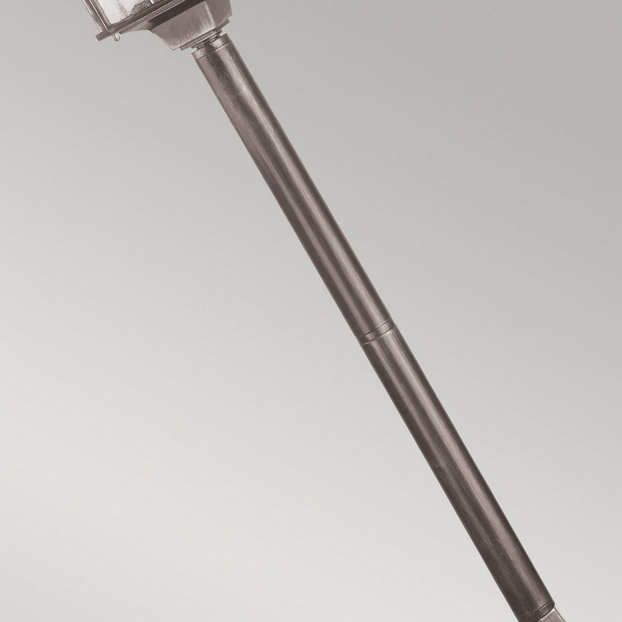 The Wexford 1 Light Pillar Light in Black/Silver is set against a plain gray background, tilted diagonally. This outdoor lighting fixture features a traditional design crafted from durable materials and includes a round glass enclosure at the top.