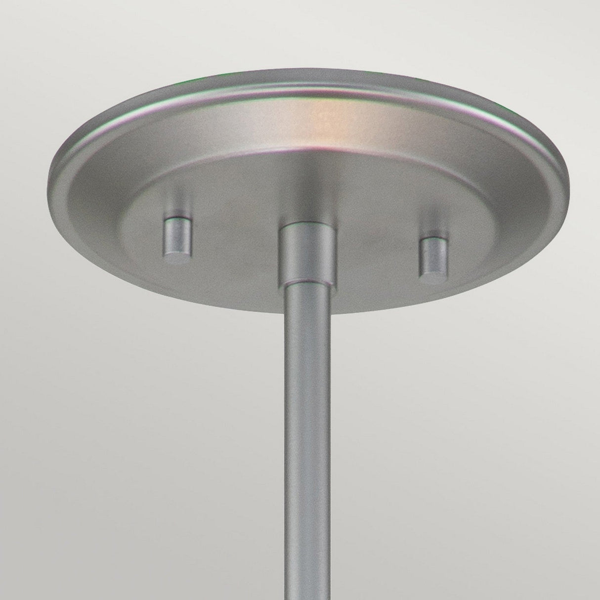 Close-up of the ceiling canopy from the Ziggy 1 Light Duo-Mount Small Pendant/Semi-Flush in Lacquered Silver, featuring a brushed metal finish. The circular canopy has two small protrusions flanking the rod, evoking modern lighting design, set against a light-colored background.