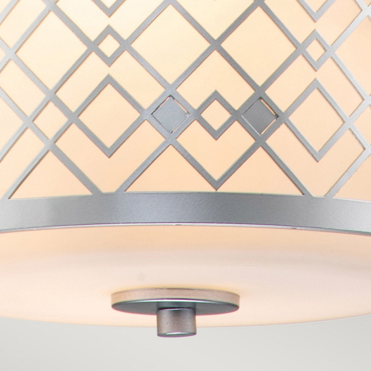 Close-up of the Ziggy 1 Light Duo-Mount Small Pendant/Semi-Flush finished in lacquered silver, featuring a white frosted glass shade with a geometric lattice pattern in gray. This modern lighting piece is enhanced by a circular metal accent at its bottom center, adding elegance to your space.