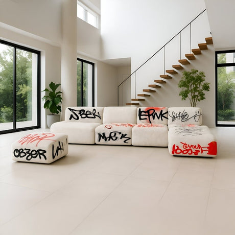 Modern open space with white cube seating featuring graffiti-style designs, large windows, and minimalist decor for an edgy contemporary vibe.