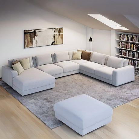 Large white sectional in a cozy loft living area with bookshelves, skylights, and neutral decor creating a clean, relaxed family space.