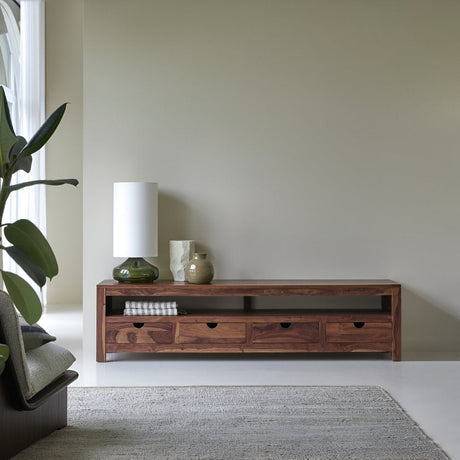 Low wooden media console with mixed wood tones, styled with lamps and décor against a muted wall in a calm, contemporary living space.