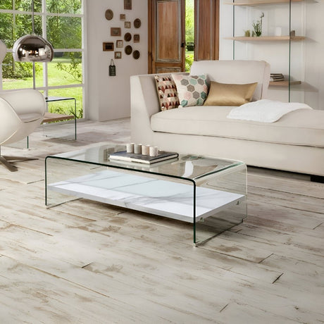 Bright living room with a sleek glass coffee table, white sofa, and modern accents, creating an airy, clean, and inviting contemporary space.