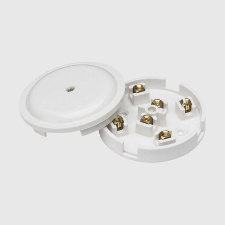 Black circular electrical junction box open to show four gold connectors inside, used for wiring connections. The lid is placed beside the base.