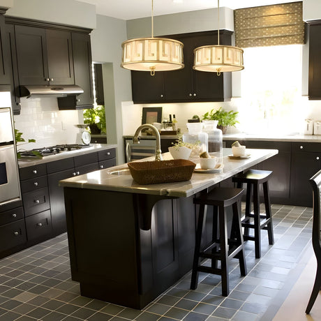 A modern kitchen with dark cabinets, stainless steel appliances, a center island with stools, pendant lights, and the text Gilded Nola below the image.