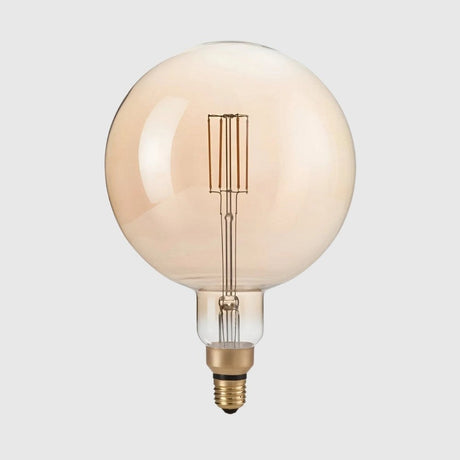 A large vintage-style light bulb with a round, amber-tinted glass and visible filament, set against a light gray background.