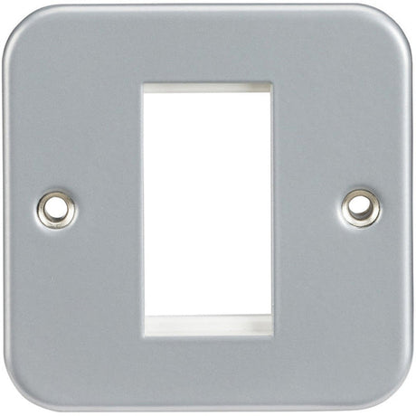 A silver metal wall plate with a rectangular central opening and two screw holes, one on each side, designed for mounting over a light switch or outlet.