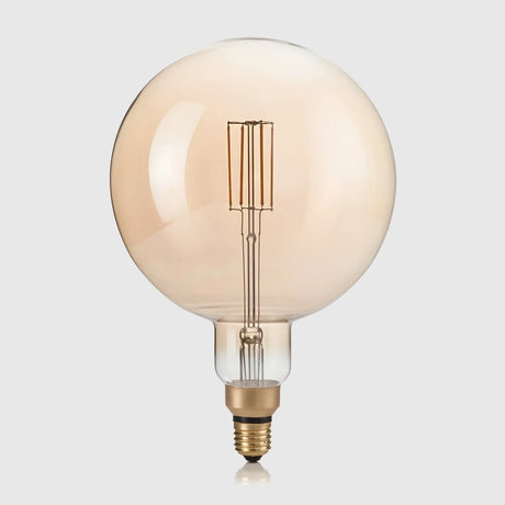 A large vintage-style light bulb with a round, amber-tinted glass and visible filament, set against a light gray background.