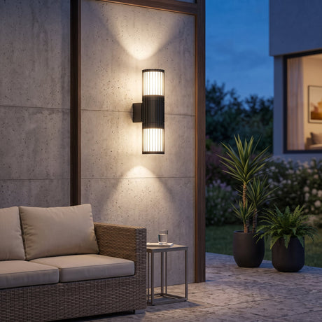 Volga 2 Light Up Down Outdoor Wall Light in anthracite, a slatted aluminium cylinder fixture with warm white glow, mounted on a wall bracket against a plain white background.