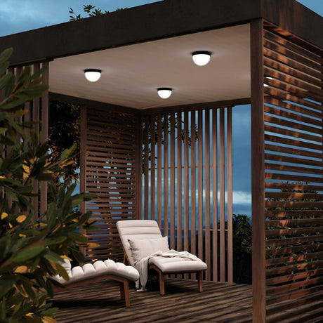 Covered patio with recessed ceiling lights and wooden lounge chairs.