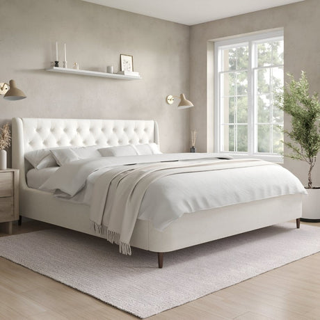 Cream upholstered platform bed with a softly tufted headboard, styled in a serene bedroom with warm lighting, minimal wall decor, and a cozy, neutral color palette.