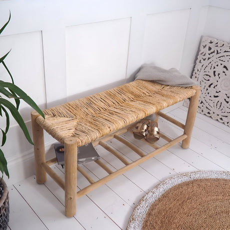 Natural woven bench with a sturdy wooden frame, placed on a light floor in a bright entry or hallway, complemented by greenery and neutral decor for an inviting, organic feel.