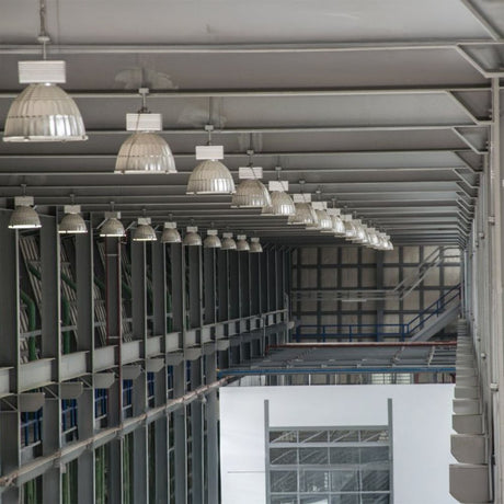 Industrial interior with hanging dome lights and high metal ceiling.