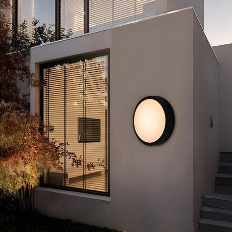 Contemporary building exterior with round wall light and wooden window slats.