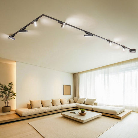 Minimalist living room with beige sofa and angular black ceiling track lights.