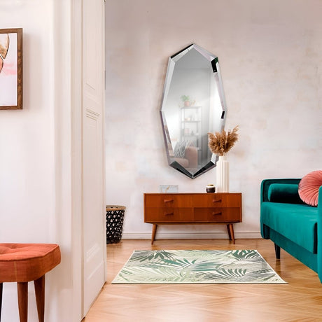 Entryway with an angular wall mirror above a warm wood console, styled with minimal decor and a teal sofa nearby for a clean modern look.
