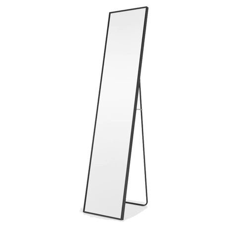 A tall, rectangular floor mirror with a sleek black frame, supported by a thin black stand. Its positioned at a slight angle, showcasing its minimalist and modern design against a white background.