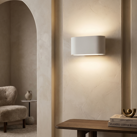A modern square white wall light with a circular indented center, softly glowing, and two perforated metal flaps extending from each side, designed for flush mounting.