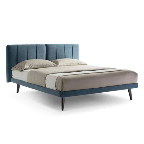 Modern bed with a light blue upholstered headboard and frame, accompanied by beige bedding and pillows. The bed has sleek black legs and a minimalist design, creating a contemporary bedroom look.