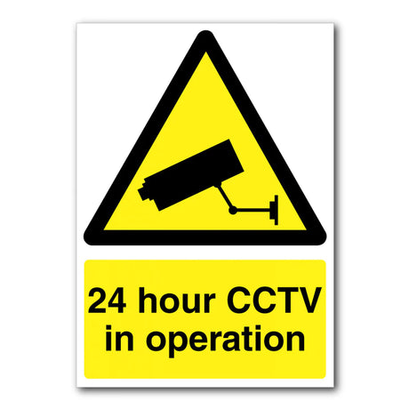 Yellow and black triangular sign with an image of a CCTV camera. Text below reads 24 hour CCTV in operation in bold black letters on a yellow background.