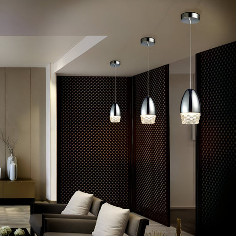 Modern interior with three sleek pendant lights hanging above a seating area. The room features dark, perforated panel walls, a neutral-toned sofa, and decorative vases on a side table.