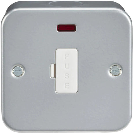 A metallic wall-mounted fused switch with a white switch labeled FUSE. Theres a small rectangular red indicator above the switch and two screws on either side in a square casing.