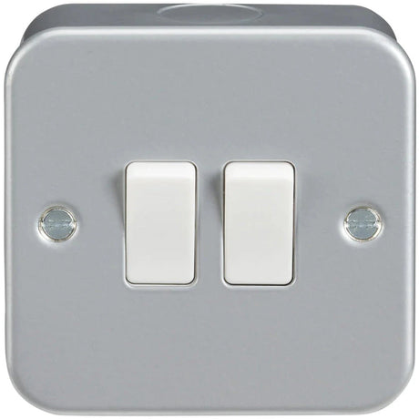 A square, metallic light switch panel featuring two white toggle switches, mounted with two visible screws on the left and right sides.