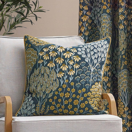 Teal floral jacquard cushion with gold piping on a cream armchair