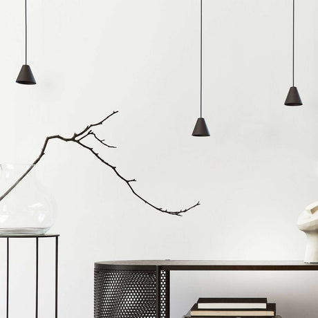 Rimini LED Cone Pendant Light in matt black, three small conical shades on black textile cables hanging at varying heights in a living room setting.
