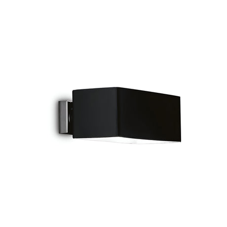 The Sage 2 Light Wall Light - Black, featuring a modern black and silver rectangular design, exudes minimalist elegance. Mounted on a sleek silver base, this fixture casts ambient lighting downward against a plain white background, perfectly embodying contemporary sophistication.