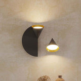 Rubi wall light with cone-shaped opal glass shade and half-disc back plate in matt black and gold, shown illuminated on a wall with a smaller matching cone wall light alongside.