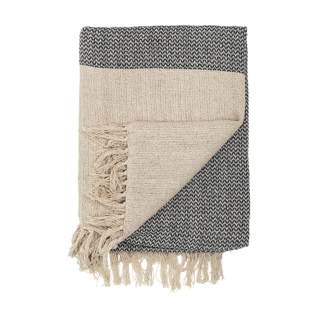 Matt Throw in beige, folded to show a plain open weave on one side and a flecked charcoal zigzag weave on the reverse, with long loose fringe, on a white background.