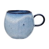 Sandrine Stoneware Cup 275ml in blue, a rounded ceramic mug with speckled reactive glaze, darker rim and loop handle, shown on a plain white background.