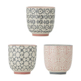 Cécile Cup 150ml ceramic cups in three assorted designs: cream with navy floral or scroll patterns and pink rims, and cream with coral geometric pattern and grey rim, on a white background.