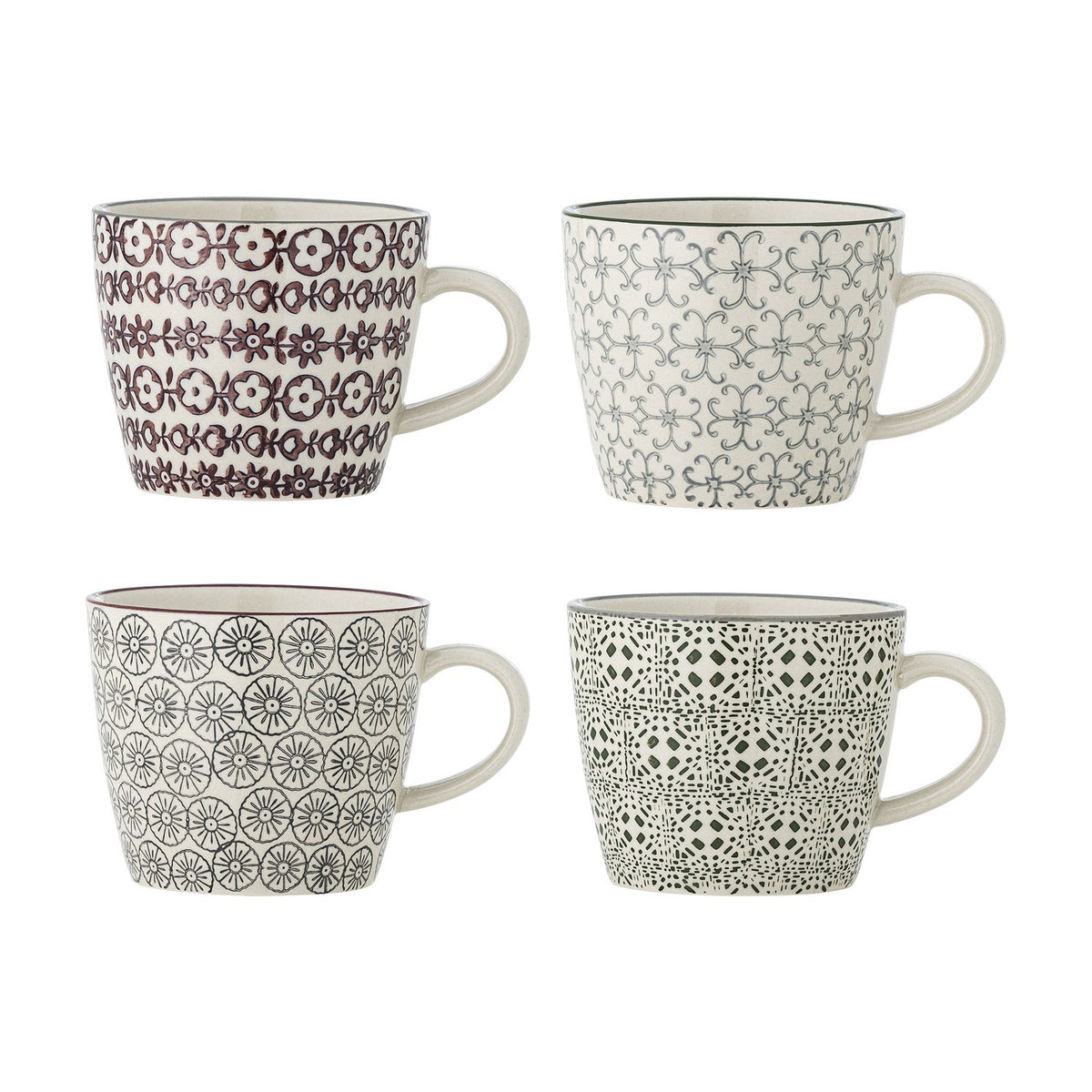 Karine Mug in four assorted stoneware designs with handles, each handstamped in a different pattern—small flowers, scrolling lattice, rosette circles, or tiled motif—on a plain white background.